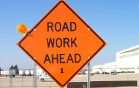 Orange sign saying road work ahead
