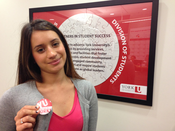 Despina Ikik, a club peer mentor in Student Community and Leadership Development, shows off her YU Belong button
