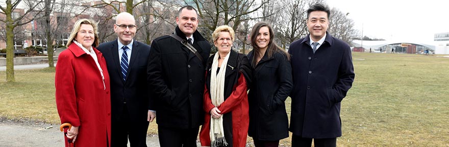 From Left: Minister Helena Jaczek, Minister Steven Del Duca, PhD student Jesse Thistle, Premier Kathleen Wynne, PhD student Dessi Zaharieva and MPP Han Dong take a photo in front of the site of York University Subway Station.