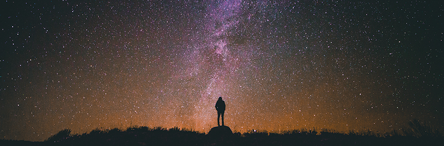 A person looks up at the night sky