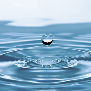 A stylized drop of water is suspended over a larger body of water