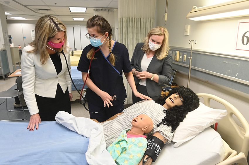 Jill Dunlop, minister of colleges and universities, watches as nursing student Diana Dzhumabaeva demonstrates a high fidelity mannequin used to teach students in York University's program. Looking on is President and Vice-Chancellor Rhonda L. Lenton 