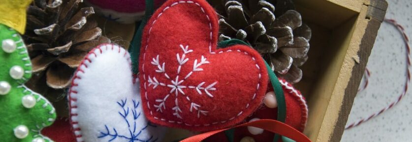 Holiday ornament hearts in a box with pine cones