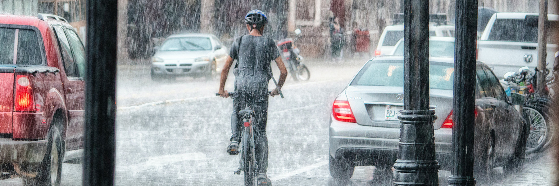boy rides a bike in a heavy rainstorm