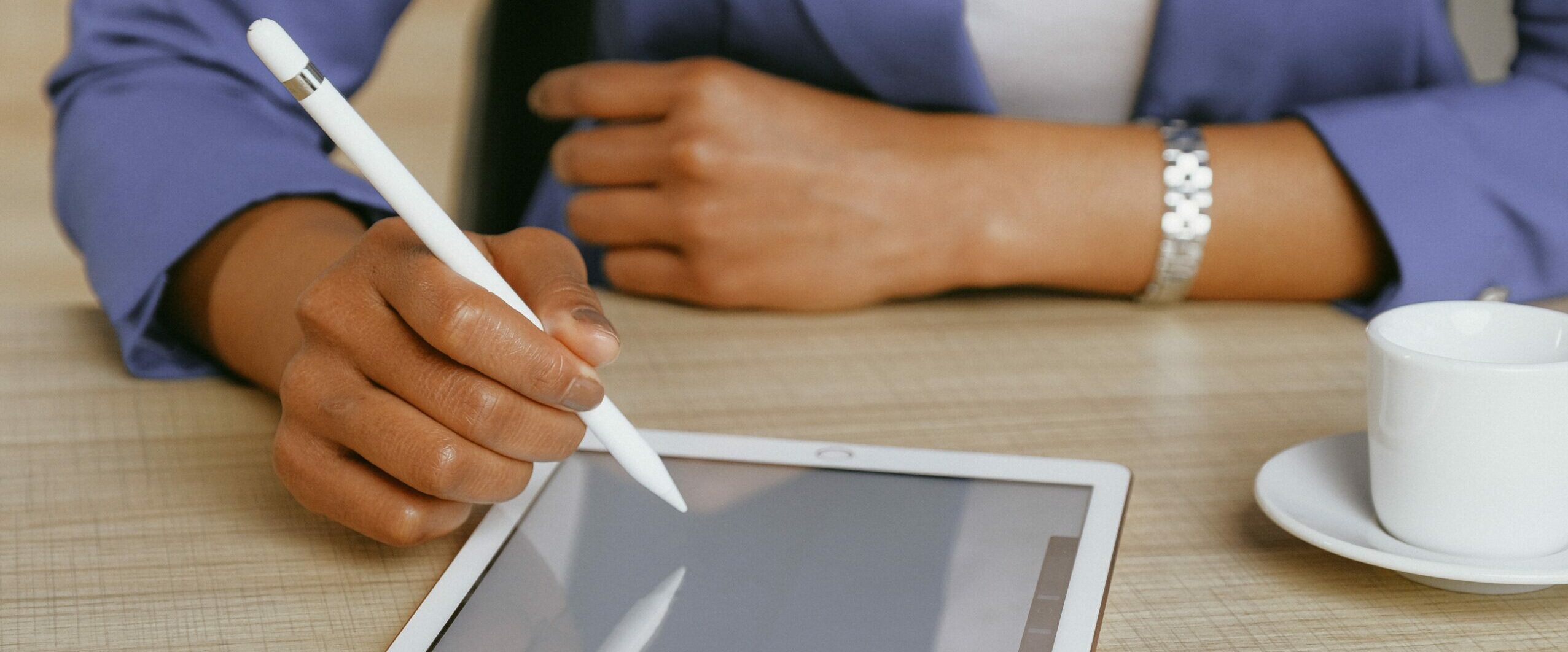 Black woman's hands using stylus on tablet