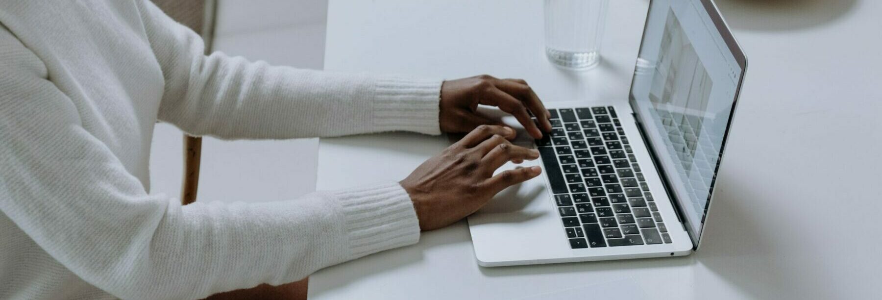 Black woman typing on a laptop