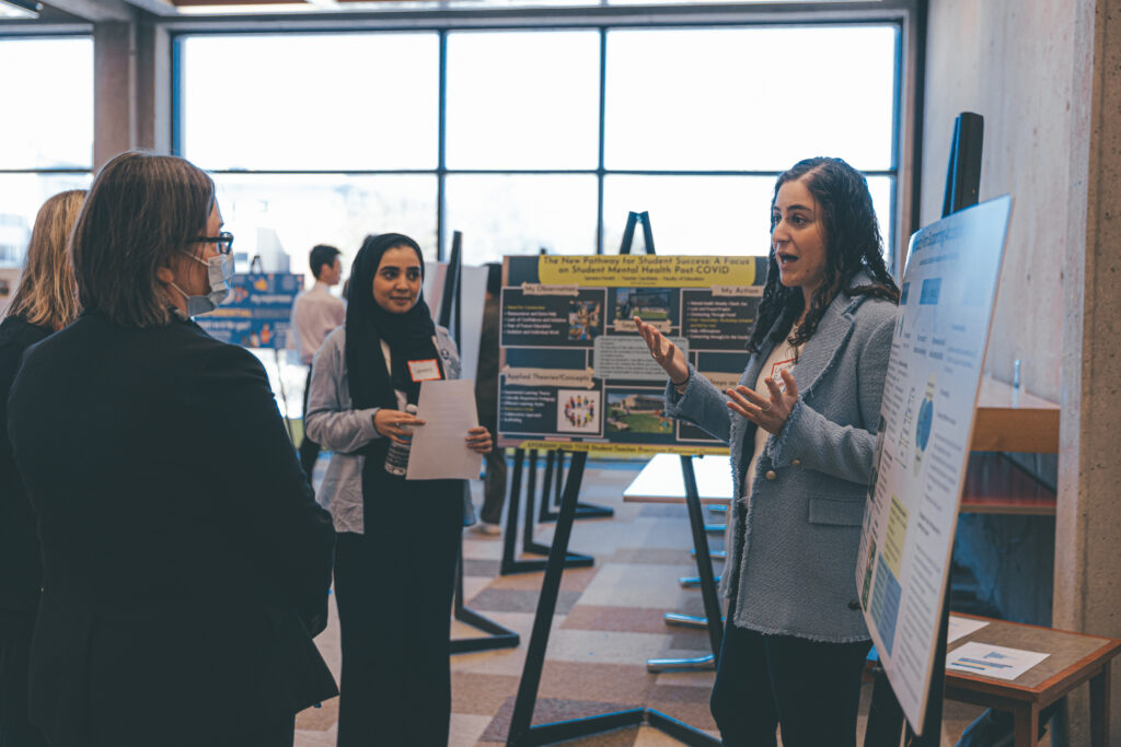 2. Lauren Rudolph, a third-year psychology student, explains her EE poster to attendees at the Student EE Symposium.