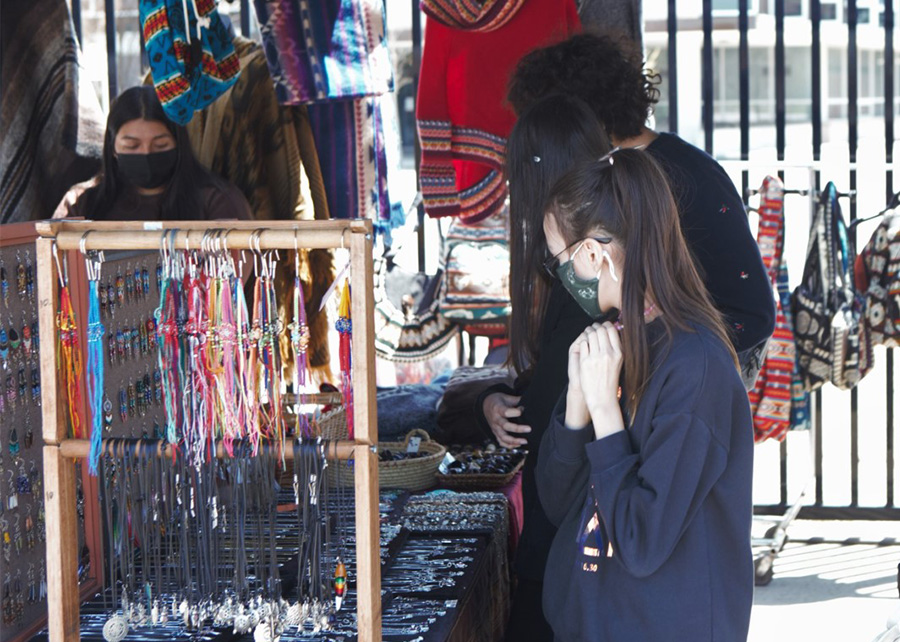 Students peruse wears produced and sold by local Indigenous craftspeople at the Indigenous Spring Market