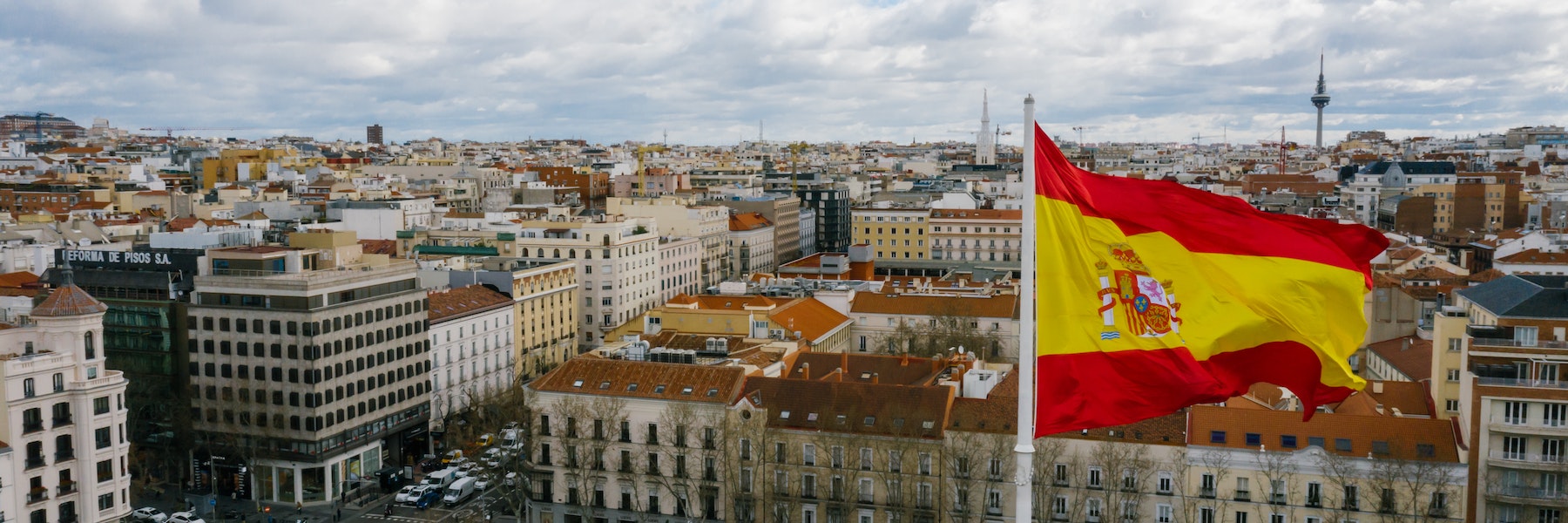 Spanish flag fluttering above a city