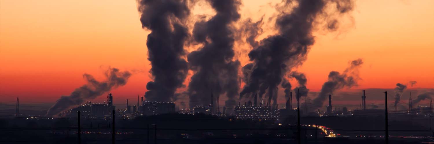 Heavily industrialized area with clouds of pollution looming in the sky at sunset, pollution, haze, smog