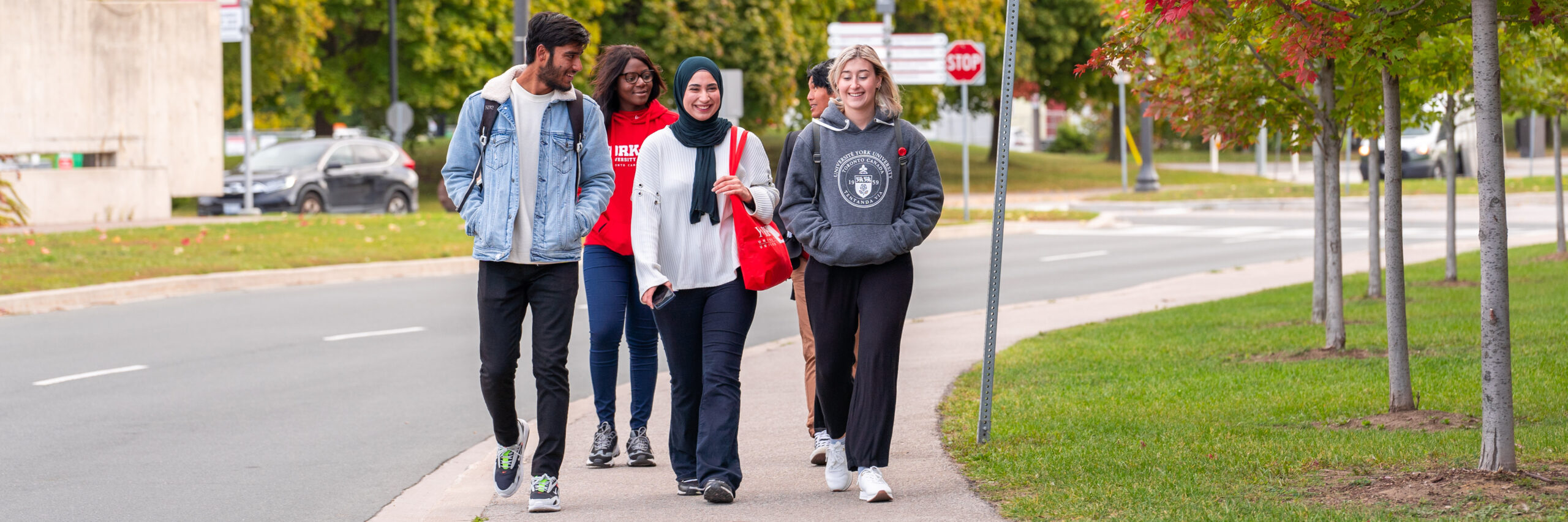 A group of five York University students walking down York Boulevard in the fall