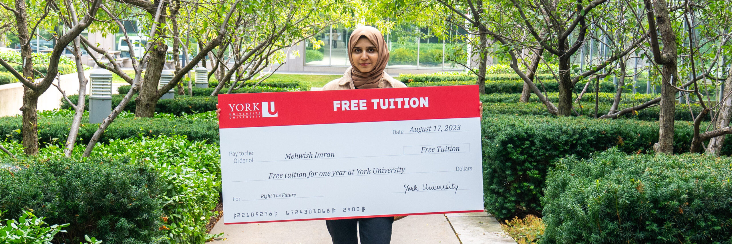 Mehwish Imran holding oversized tuition cheque