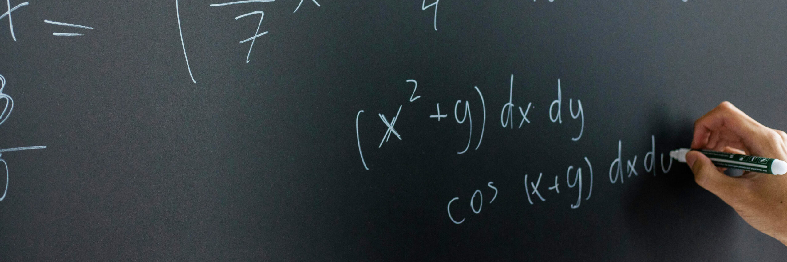 student writing math on chalkboard BANNER