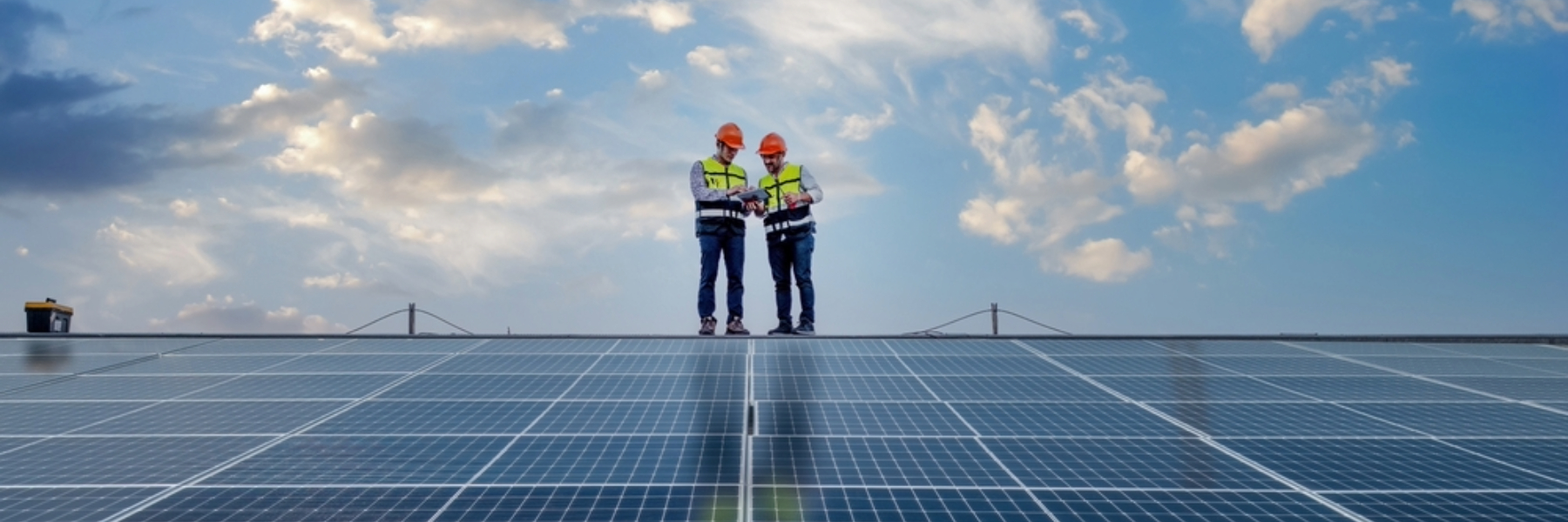 Two engineers working on solar panel roof