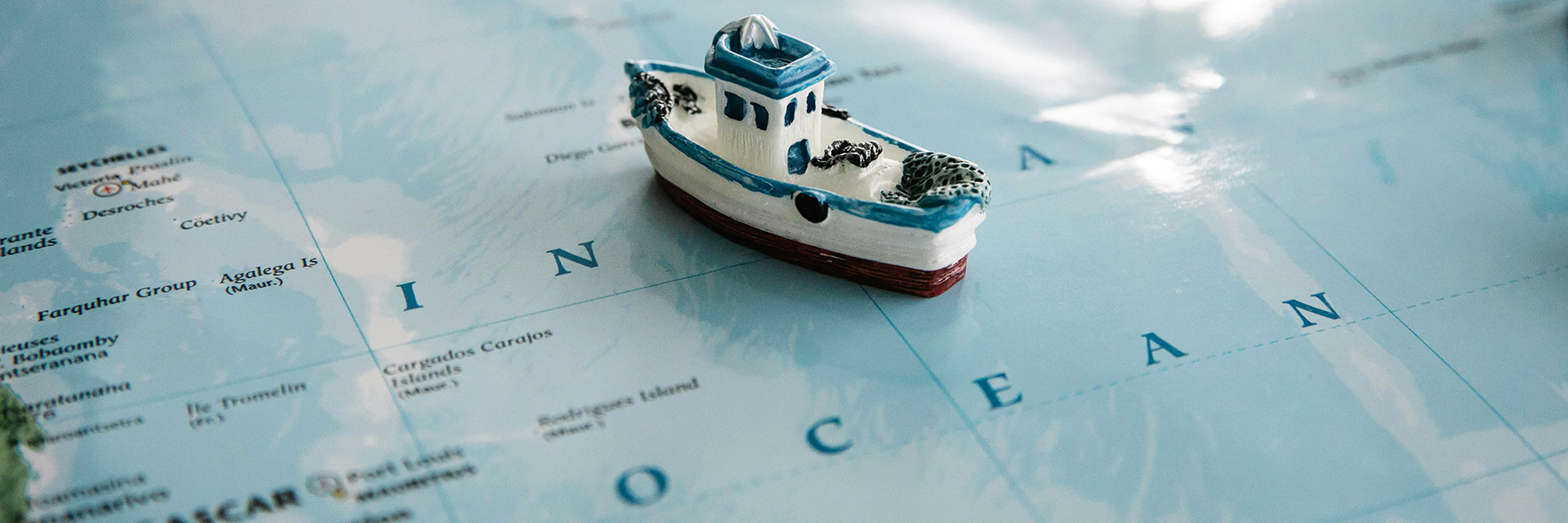 Toy boat on a map of the Indian Ocean BANNER